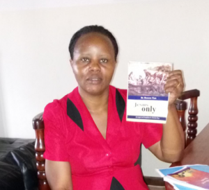 Pr Barungi is happy to receive the Jesus Only book to share with her congregation.