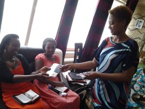 Priscilla giving the book "Jesus Only" to her friends at the gospel fellowship she started in her home the afternoon of her baptism.